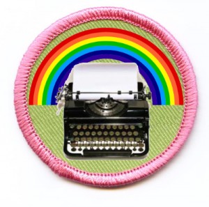 A merit badge with a rainbow behind a typewriter.