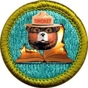 A merit badge with a Smokey the Bear face on top of a burning book.