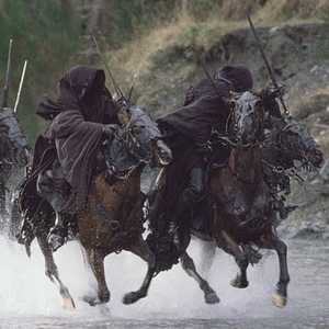 The ringwraiths from LORD OF THE RINGS on horseback in a river.