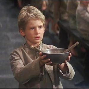 Oliver Twist holds up an empty bowl to ask for more food