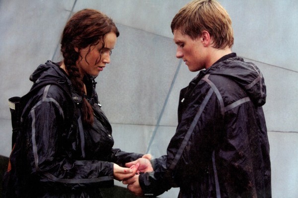 Screenshot from The Hunger Games, with Katniss and Peeta facing each other, deciding to eat poison berries