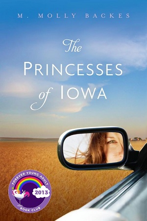 A girl's face in the side mirror of her car, backed by an open field and blue sky