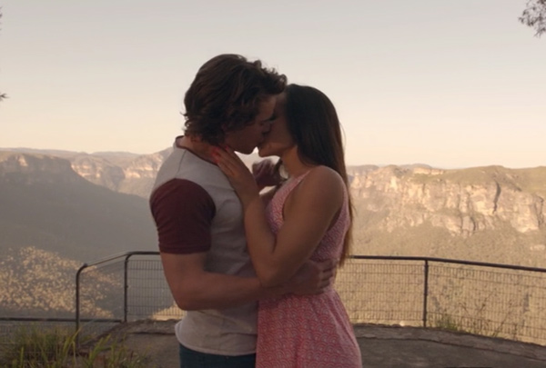 Wes and Abigail kissing with beautiful scenery in the background