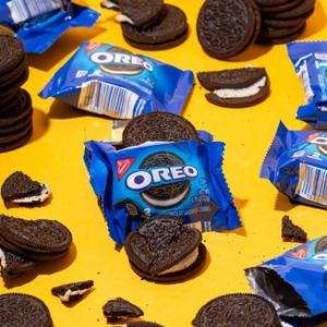 Oreos, some in individual wrappers, scattered on a bright yellow surface