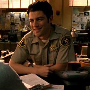 Leo sitting at his police desk.
