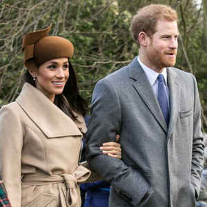 Meghan Markle and Prince Harry standing outside in coats