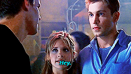 Buffy, standing between Angel and Owen, a tall broad-shouldered blonde guy, at the Bronze