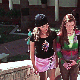 Buffy wearing a black knit cap, a black tight-fitting graphic tee and a pink satin mini-skirt