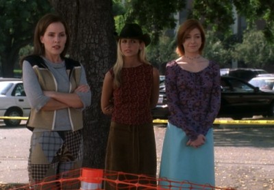 Anya, Buffy, and Willow stand outside in assorted strange outfits