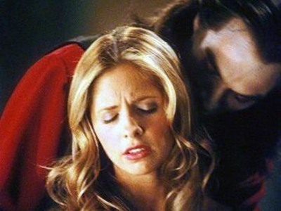 Dracula hovers behind Buffy, whose eyes are closed