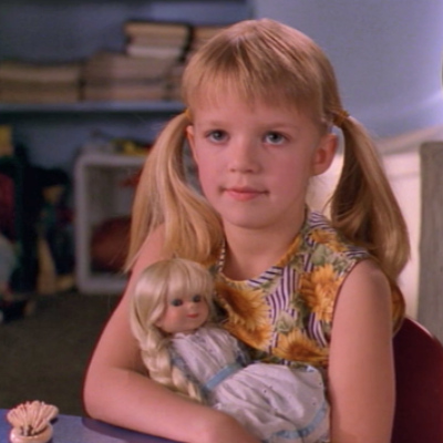 A child Buffy holding a doll.