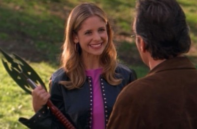 The Buffybot holds a weapon while grinning at Giles