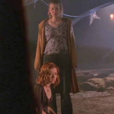 Tara stands in a sewer looking at Willow sitting on the ground, having just found out she caused their amnesia with a bad spell.