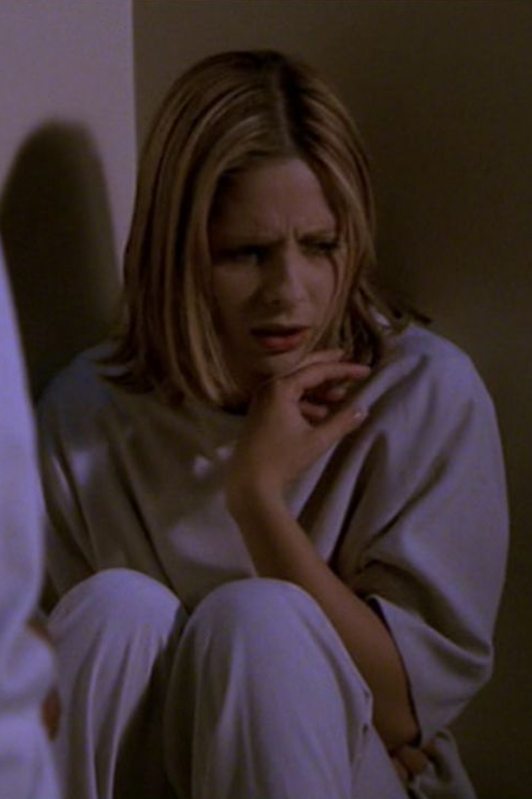 Buffy, wearing hospital scrubs and sitting in a corner