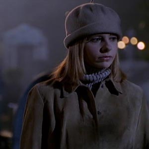 Buffy wearing a coat and a beige hat that's a cross between a beanie and a beret