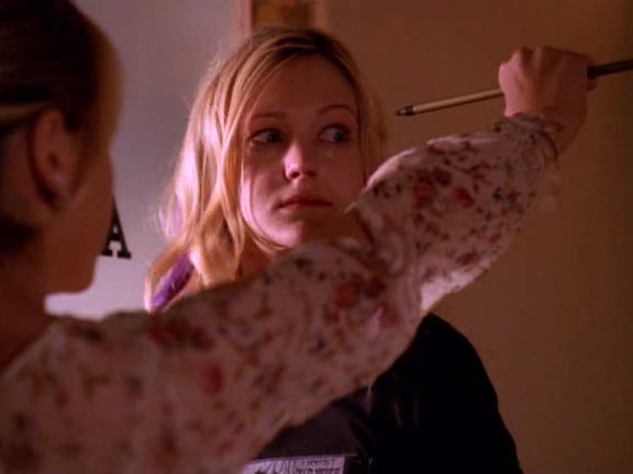 Buffy holding an arrow she caught right before it hit Cassie