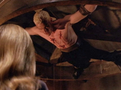 Spike hangs from the ceiling bleeding as the First Evil as Buffy watches.
