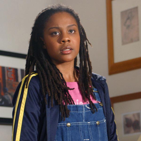 Rona, a Black girl with long hair in braids, wearing overalls