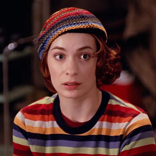 Violet, with chin-length auburn hair and a striped shirt and matching hat