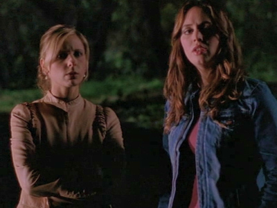 Buffy and Faith standing outside in the dark.