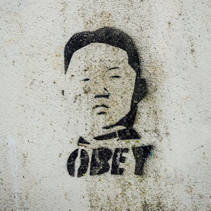 Graffiti of a dictator's face with the words "OBEY" underneath