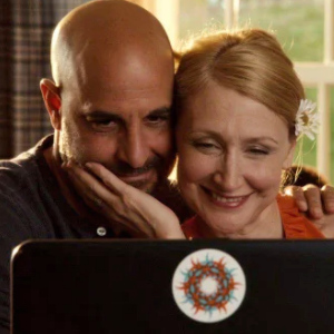Parents from Easy A smiling and looking into a laptop during a video chat
