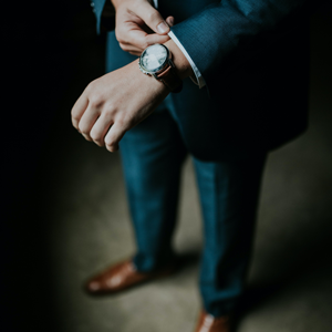 Man in a suit fixing his sleeve.