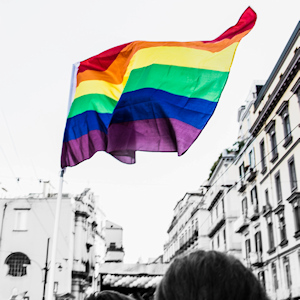 Pride flag being waved in a parade