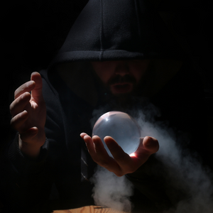 A person holds a crystal ball in their hands in the dark