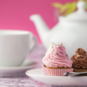 Tea kettle and teacup with pink and chocolate cupcakes