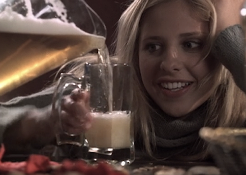 Buffy eagerly watching a pitcher of beer being poured into her glass.