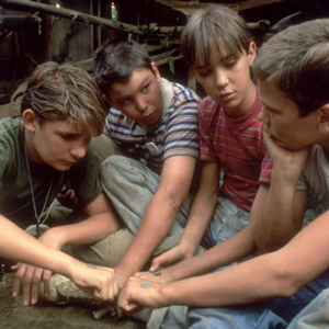 Screenshot from Stand By Me, with the four best friends putting their hands together to form a pact