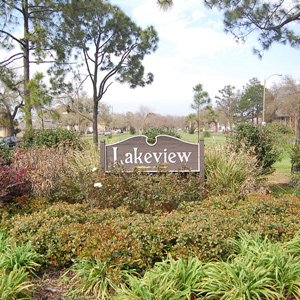 Wooden sign for Lakeview surrounded by trees and plants