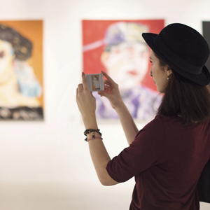 girl using iphone to take photo in an art gallery