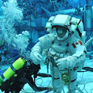 Astronaut in full gear under the water doing training