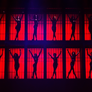 Silhouettes of women in jail cells against a red background from the musical Chicago