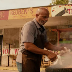 A man grilling on a barbeque outside, from The Hate U Give