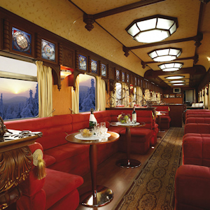 Inside a dining car of a train with nice finishes and red velvet seats