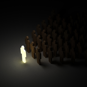 A little cartoon person all lit up standing in front of other little people who are standing in the dark.