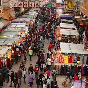 A large outdoor market with lots of shoppers