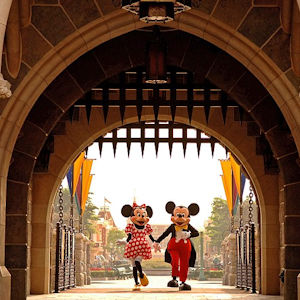 Minnie and Mickey walking through Cinderella's castle's gate