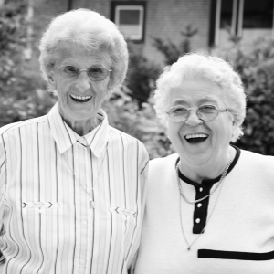 B&W picture of two older women smiling at the camera