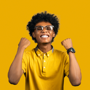 Man standing in front of a yellow background holding his fists up in victory.