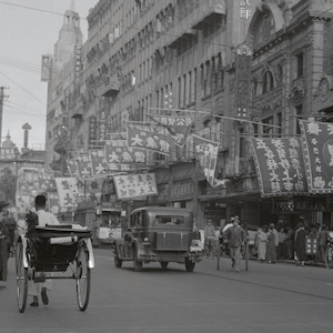 A street with cars and horse-drawn horses in 1930s Shanghi, China