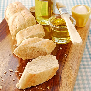 Cut french bread and honey on a wooden cutting board