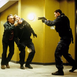 Scene from Speed: Keanu Reeves holding a gun at Dennis Hopper, who is holding Jeff Daniels hostage with a gun