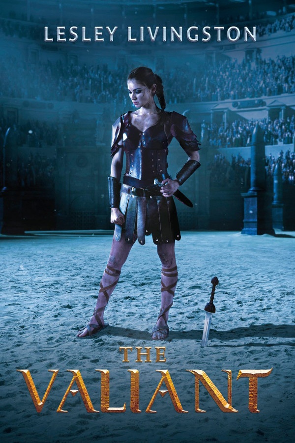 A girl in gladiator armor stands in the middle of a coliseum with a knife in the sand beside her.