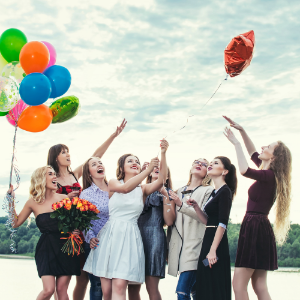 A group of women together holding balloons