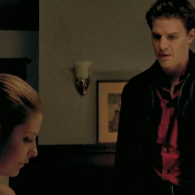 Buffy's dining room, she looks upset while Angel stands over her.