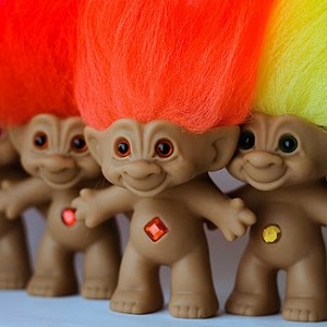 Three troll dolls, with neon long hair and shiny gems in their belly buttons